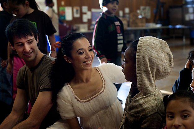 Nutcracker dancers engaging with young students in conversation.