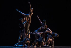 Dancers posing with a very faint light coming from the right