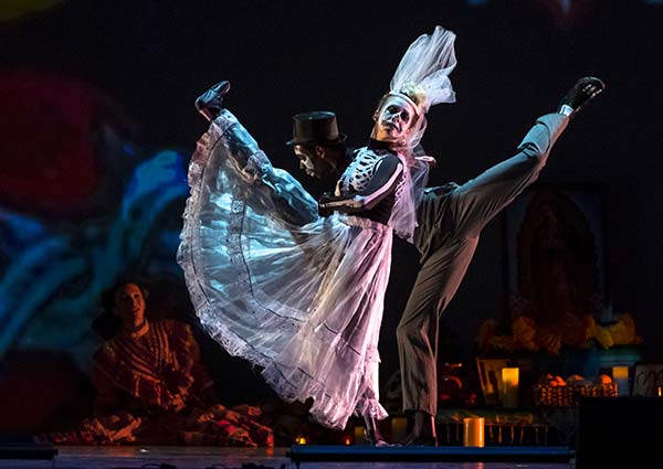 Skeleton bridge and partner perform duet kicking legs high in the air.