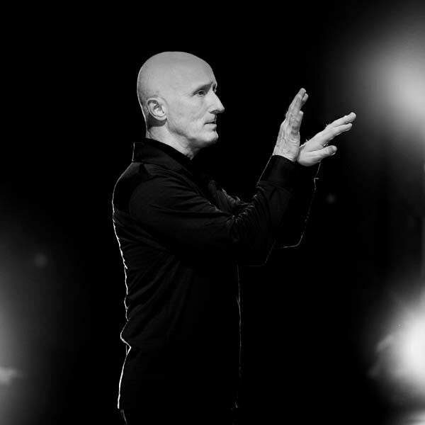 HEADER-ArtisticDirector-OaklandBallet-GrahamLustig Graham Lustig looking to the right with his hands up.