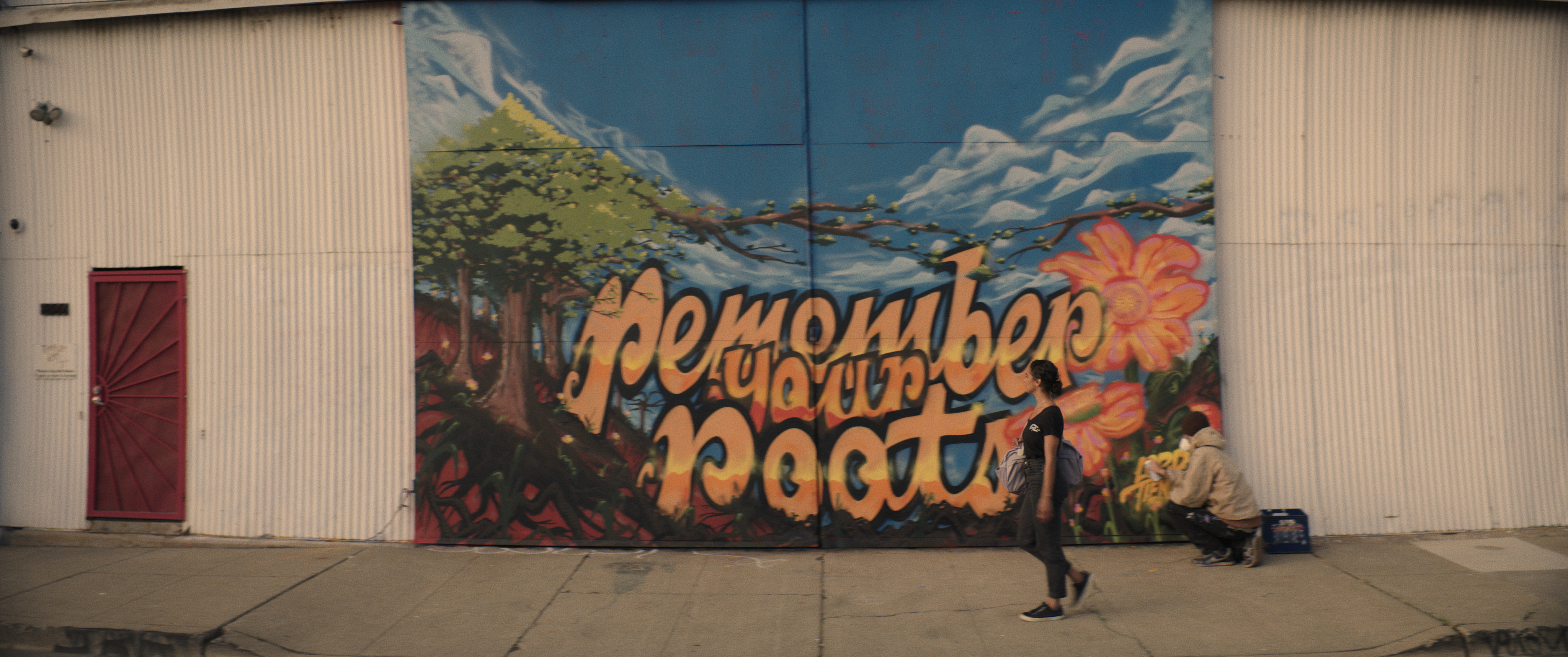 misty_walking_wide Misty Copeland walking in front of mural that says "remember your roots"