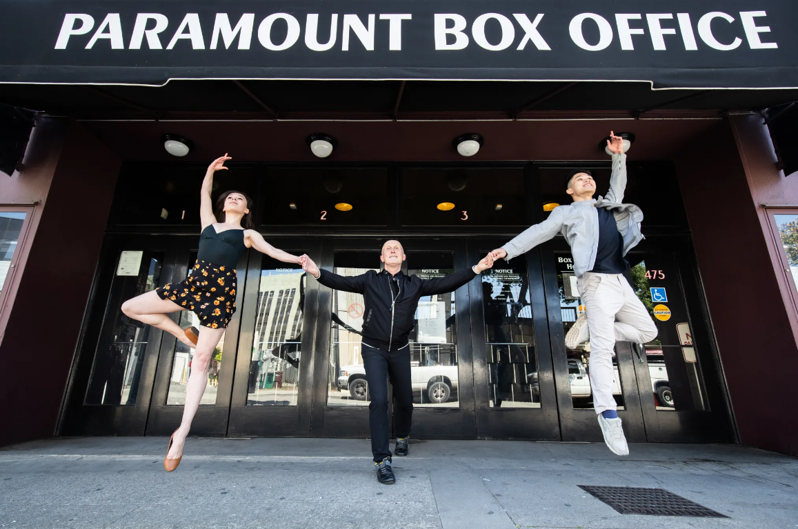 Paramount Photo Two dancers on side jumping while dancer in the middle holds their hands