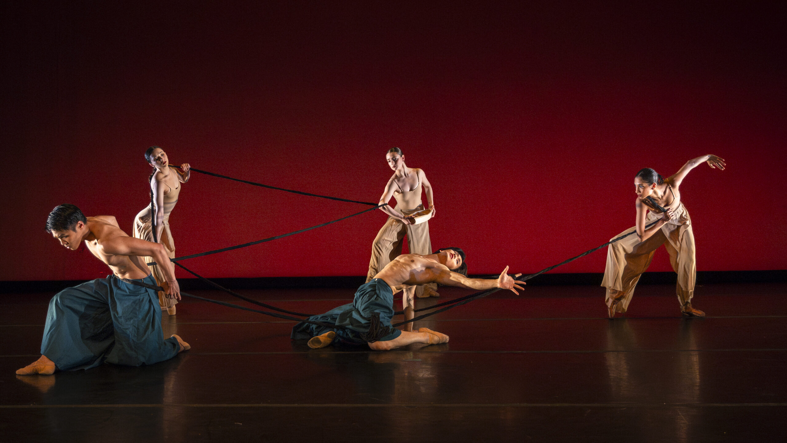 _J1A0756-Enhanced-NR Dancers spread around the stage performing various poses connected by a long braid.