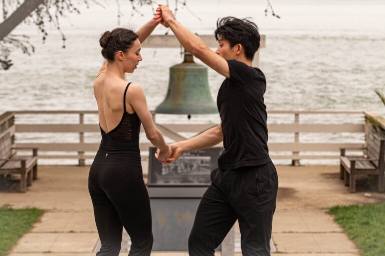 dance4-copy-768x512 Dancers Jazmine & Lawrence hold hands appearing to perform a turn in front of a bell on Angel Island.