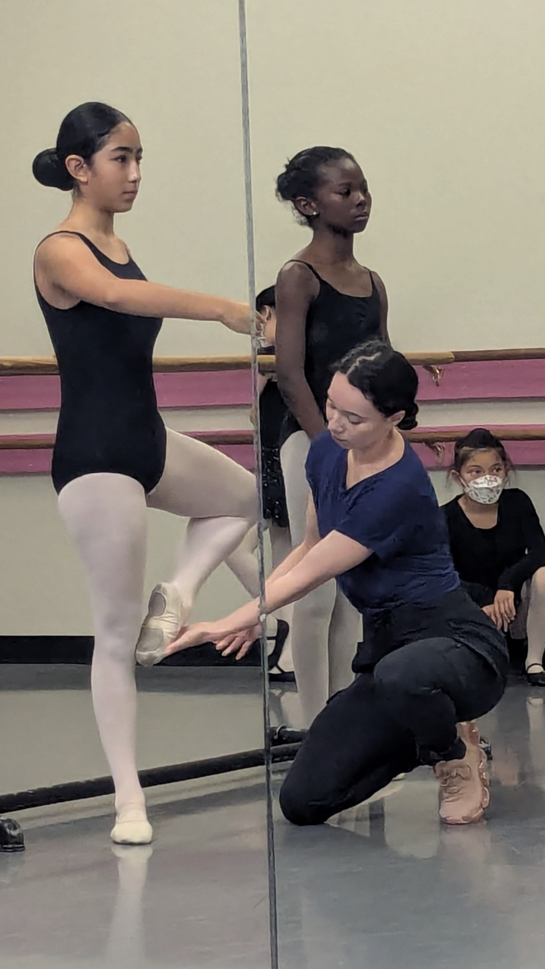 PXL_20250716_165722243 (1) - Edited Dancer holding a passe receiving feedback from kneeling instructor