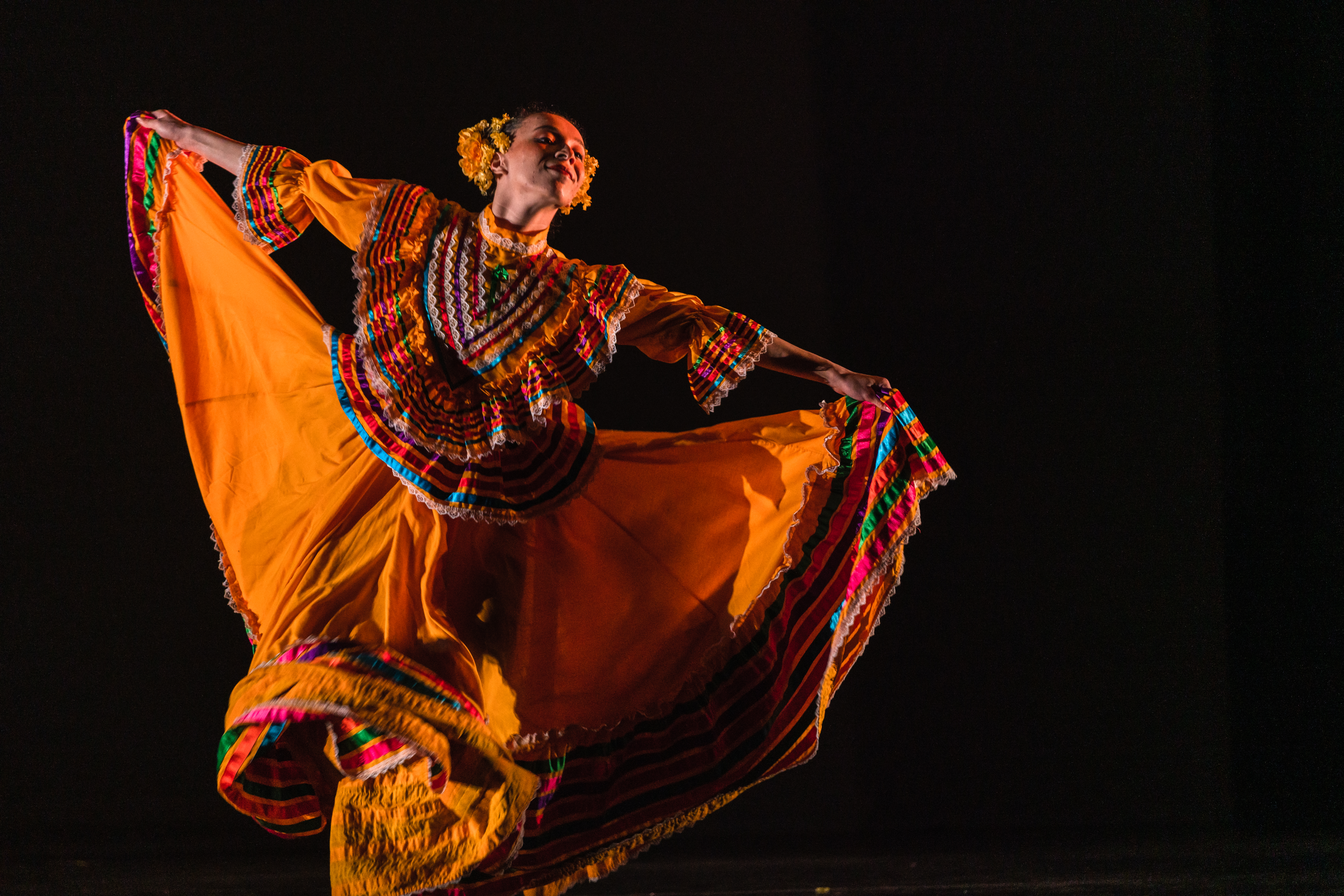 Dancer holding skirt of folkloric dress and running to the right